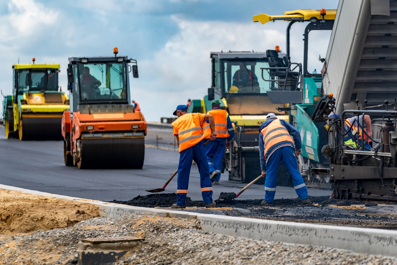 M-J tief.und Rohrleitungsbau GmbH - Arbeiter markiert Straßenrand auf Baustelle